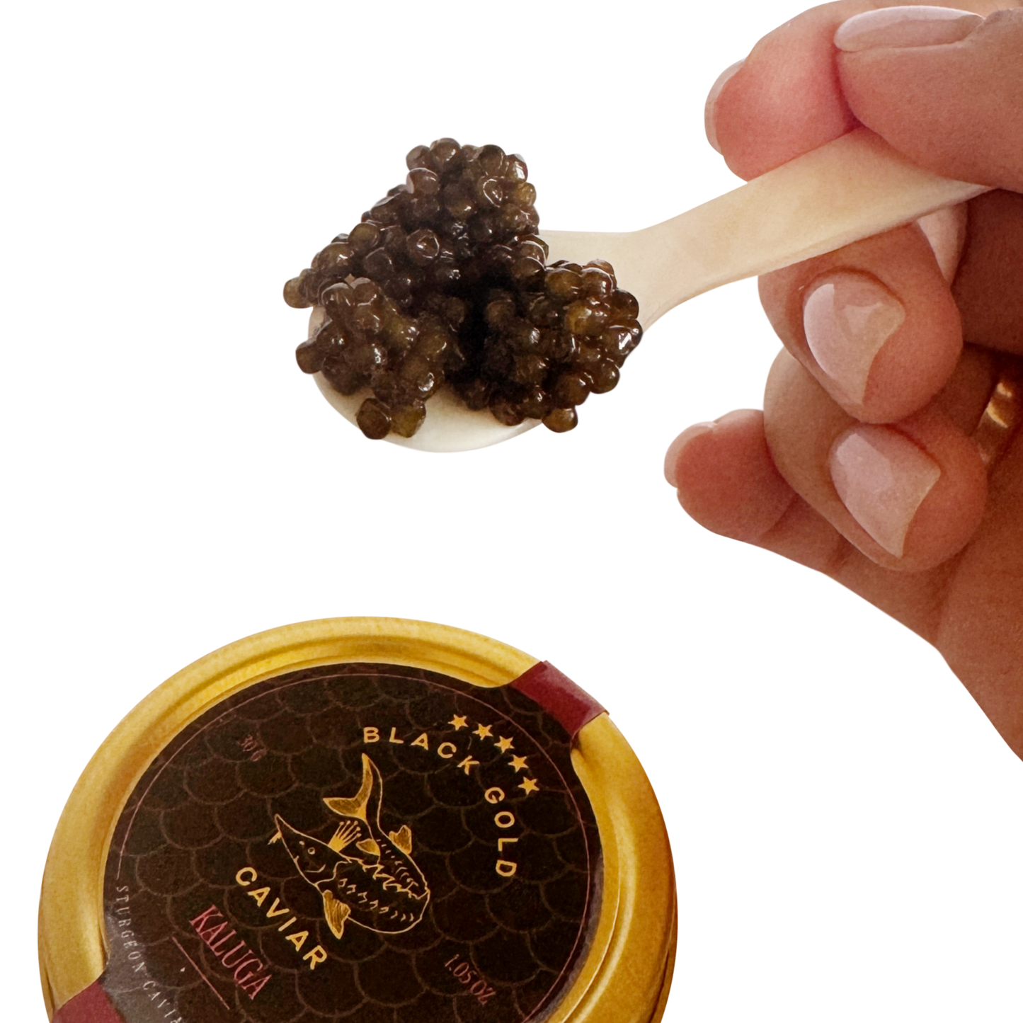 Caviar on a spoon held by a hand with a container labeled 'Black Gold Caviar' in the foreground.