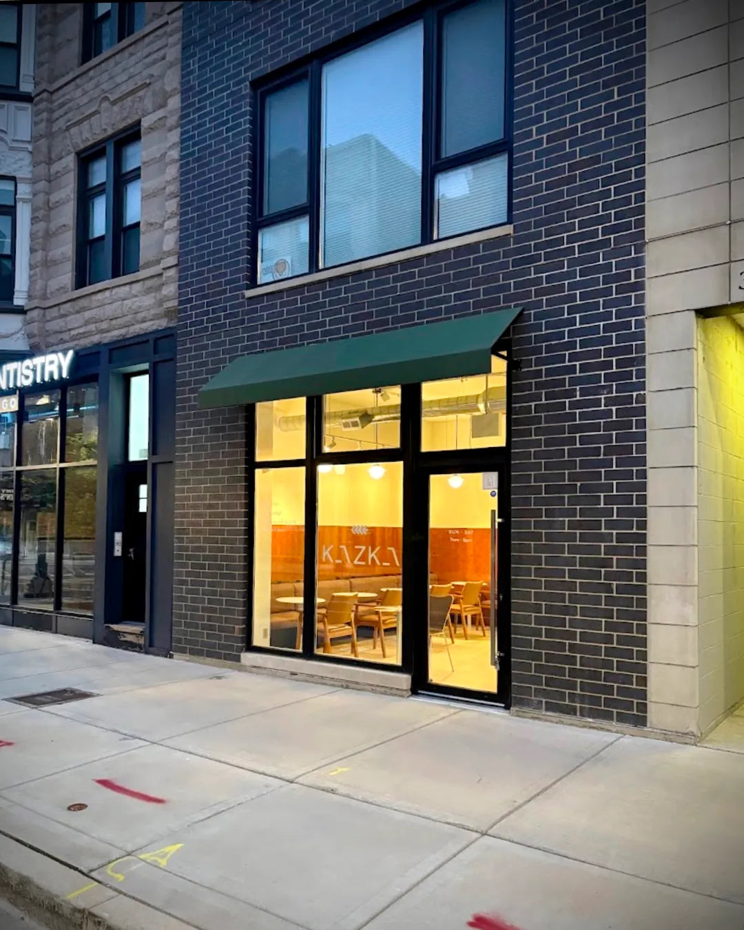 Nighttime exterior of Kazka restaurant in Chicago with lights on, serving as the caviar pick-up point